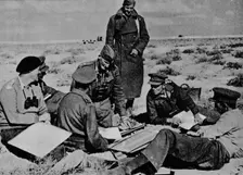 Maps and plans are spread on the sand 1942 (1944)