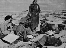 Maps and plans are spread on the sand 1942 (1944)