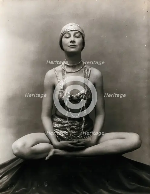 Marguerite Agniel posing with her legs crossed and hands together resting on her legs, 1929. Creator: Unknown.