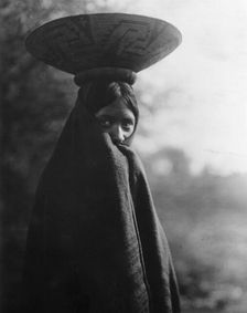 Maricopa girl, half-length portrait, standing, facing slightly right, wrapped in blanket..., c1907. Creator: Edward Sheriff Curtis