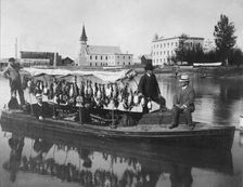 Marshall Erwin in front of a boat containing a kill of ducks, between c1900 and 1927. Creator: Unknown