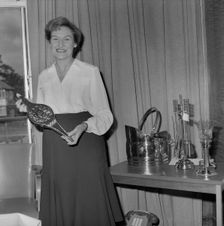 Mary Coldicott holding a brass ornamental gift, during her retirement presentation , 01/08/1986. Creator: John Laing plc