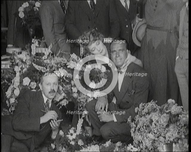 Mary Pickford and Douglas Fairbanks Senior Sitting Together Amongst a Bed of Flowers in Paris, 1920. Creator: British Pathe Ltd.