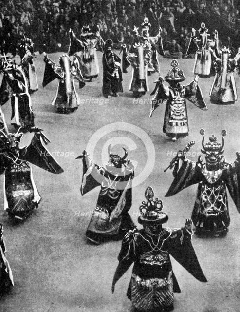 Masked dancers, Tibet, 1936.Artist: Ewing Galloway