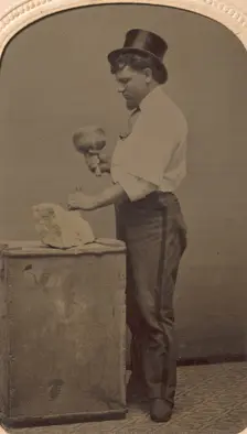 Mason in Top Hat with Mallet, Chisel, and Piece of Stone, 1870s-80s. Creator: J. R. Martin