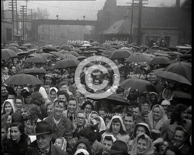 Masses of People Cheering the Train As It Passes By Many Have Umbrellas As It Is Raining, 1932. Creator: British Pathe Ltd.