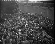 Masses of People Cheering - Many Have Umbrellas As It Is Raining, 1932. Creator: British Pathe Ltd