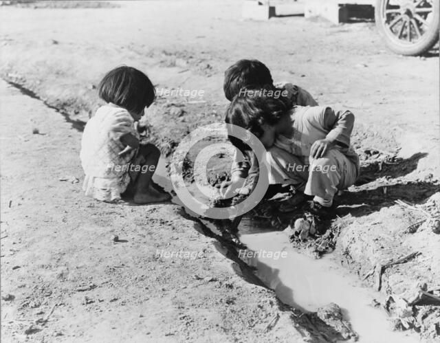 Mexican children playing in ditch, near Corcoran, California, 1936. Creator: Dorothea Lange.