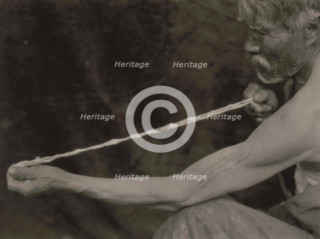 Measuring shell money-Tolowa, c1923. Creator: Edward Sheriff Curtis.