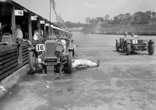 Mechanic working on a Lea Francis J type at the JCC Double Twelve race, Brooklands, May 1931. Artist: Bill Brunell