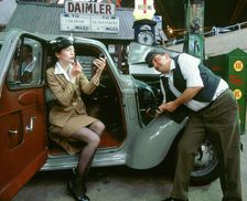 Mechanic with lady driver doing her make up, 1930's Hillman Minx