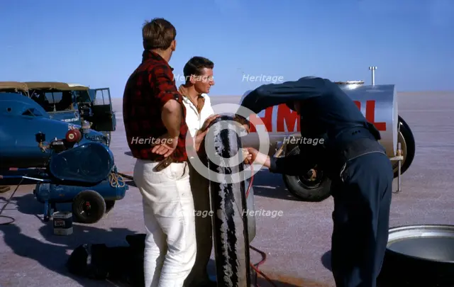Mechanics inflating Bluebird CN7 tyre for World Land Speed Record attempt, Lake Eyre, 1964. Creator: Unknown.
