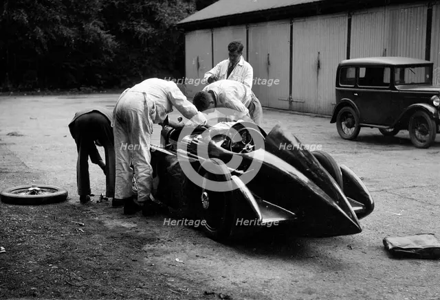 Mechanics working on Leon Cushman's Austin 7 racer for a speed record attempt, Brooklands, 1931. Artist: Bill Brunell.