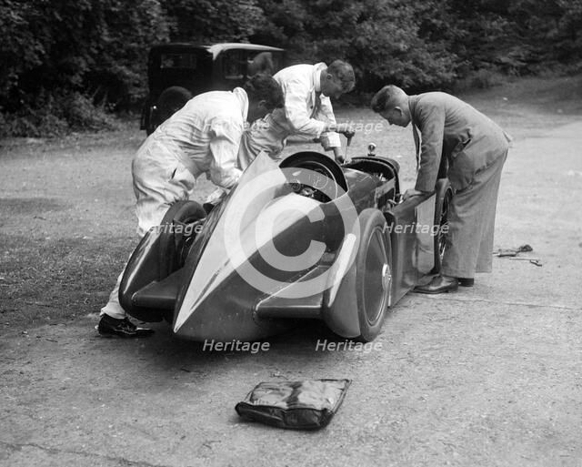 Mechanics working on Leon Cushman's Austin 7 racer for a speed record attempt, Brooklands, 1931. Artist: Bill Brunell.