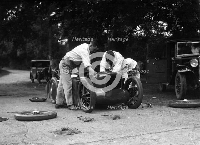 Mechanics working on Leon Cushman's Austin 7 racer for a speed record attempt, Brooklands, 1931. Artist: Bill Brunell.
