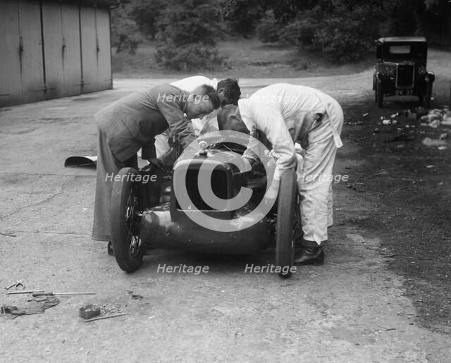 Mechanics working on Leon Cushman's Austin 7 racer for a speed record attempt, Brooklands, 1931. Artist: Bill Brunell.