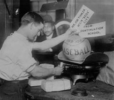 Medicine ball being weighed by Post Office employee; shipping tags read: Mr. Joe Tinker..., 1913. Creator: Bain News Service