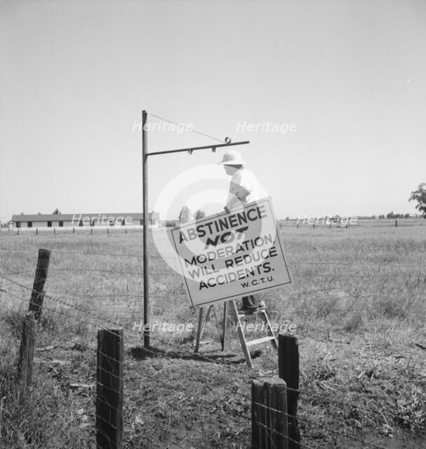 Member of the committee...erects sign on U.S. 99 highway, near Hanford, California, 1939. Creator: Dorothea Lange.