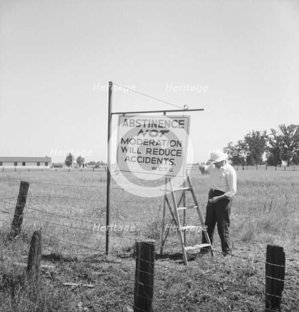 Member of the committee...erects sign on U.S. 99 highway, near Hanford, California, 1939. Creator: Dorothea Lange.