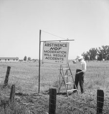 Member of the committee...erects sign on U.S. 99 highway, near Hanford, California, 1939. Creator: Dorothea Lange