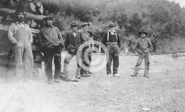 Men next to logs, between c1900 and 1916. Creator: Unknown.