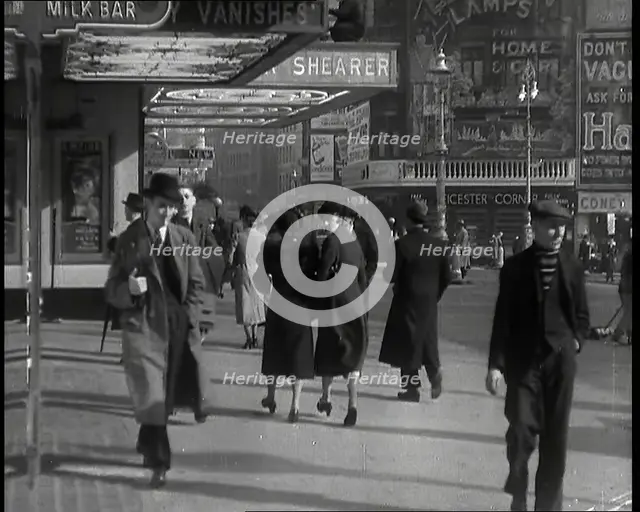 Men and Women Walking Through Leicester Square With the Leicester Corner Restaurant..., 1939. Creator: British Pathe Ltd.