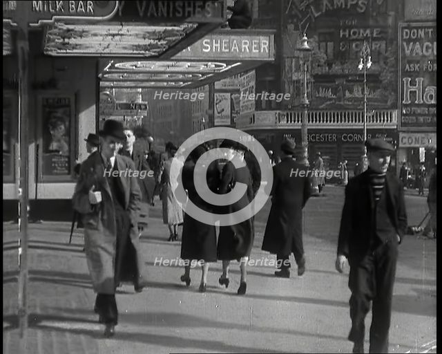 Men and Women Walking Through Leicester Square With the Leicester Corner Restaurant..., 1939. Creator: British Pathe Ltd.