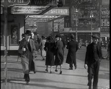 Men and Women Walking Through Leicester Square With the Leicester Corner Restaurant..., 1939. Creator: British Pathe Ltd