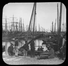 Men and boys with sailing boats in port, unknown location, c1900s. Creator: Robert Augustus Henry L'Estrange