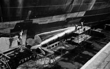 Men clean and paint the hull of a ship in the New Dry Dock, Tilbury Docks, Tilbury, c1945-c1965. Artist: SW Rawlings