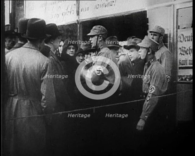 Men in Nazi Uniforms and Civilians Standing Outside a Shop With anti-Jewish Posters on it, 1933. Creator: British Pathe Ltd.