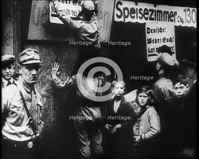 Men in Nazi Uniforms attaching anti-Jewish Posters, 1933. Creator: British Pathe Ltd.