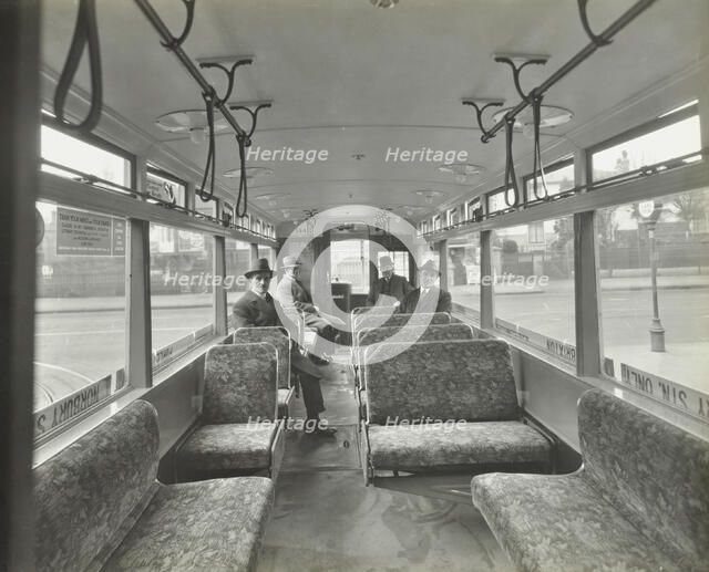 Men in hats and coats in the interior of an electric tram, London, 1933. Artist: Unknown.
