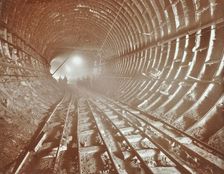 Men pushing railway trucks along the Rotherhithe Tunnel, Stepney, London, June 1907