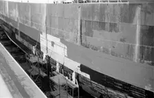 Men paint the hull of a ship in the New Dry Dock, Tilbury Docks, Tilbury, Essex, c1945-c1965. Artist: SW Rawlings