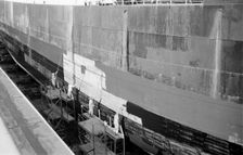 Men paint the hull of a ship in the New Dry Dock, Tilbury Docks, Tilbury, Essex, c1945-c1965. Artist: SW Rawlings