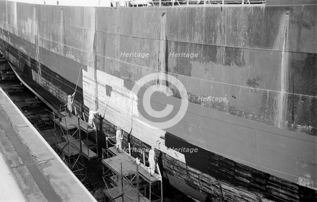 Men paint the hull of a ship in the New Dry Dock, Tilbury Docks, Tilbury, Essex, c1945-c1965. Artist: SW Rawlings