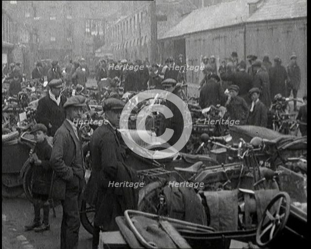Men Standing Around Groups of Motorcars and Motorbikes, 1920. Creator: British Pathe Ltd.
