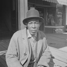 Men sitting in the sun on Sunday morning, Daytona Beach, Florida, 1943. Creator: Gordon Parks