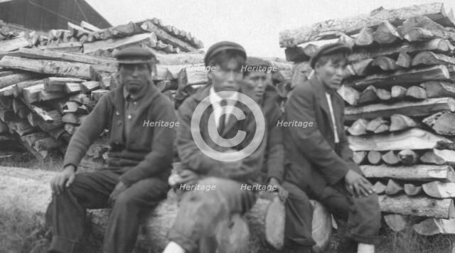 Men sitting on logs, between c1900 and 1916. Creator: Unknown.