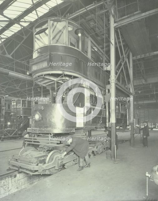Men using a car lifting hoist at Charlton Central Repair Depot, London, 1932.  Artist: Unknown.