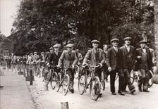 Men walk and wheel bicycles away from the Rowntree factory, York, Yorkshire, 1940