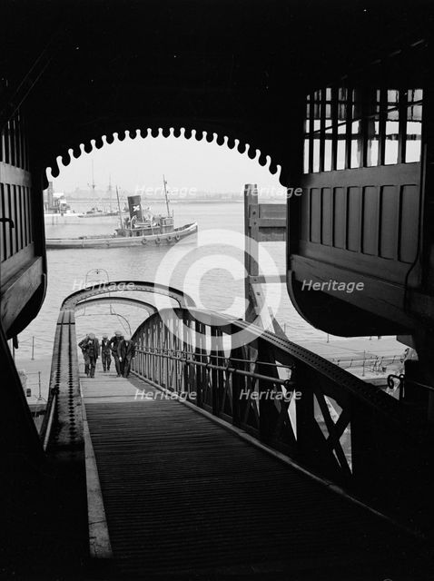 Men walking up a wooden bridge on a river, c1945-c1965.  Artist: SW Rawlings