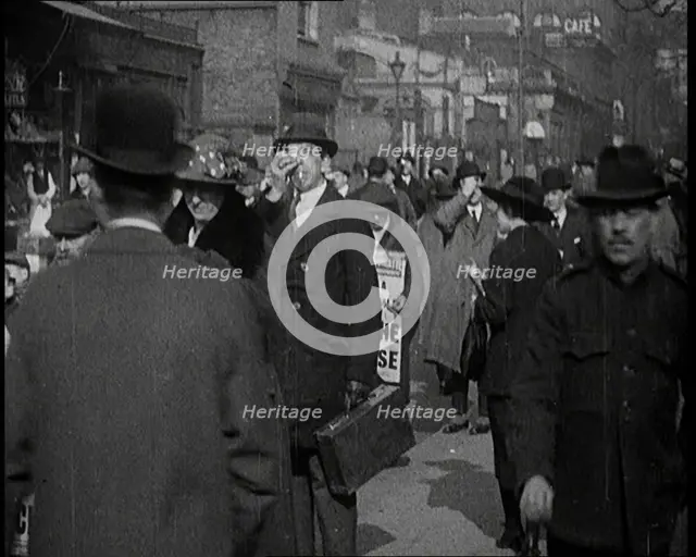 Men Wearing 'Pathe Gazette' Sandwich Boards Handing Out Pieces of Polaroid Film to Crowds..., 1921. Creator: British Pathe Ltd.