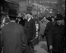 Men Wearing Pathe Gazette Sandwich Boards Handing Out Pieces of Polaroid Film to Crowds..., 1921. Creator: British Pathe Ltd