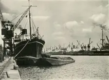 "Merchants Bring In Wares By Ships from Every Nation" Vessels alongside the Quays... 1937. Creator: J Dixon-Scott