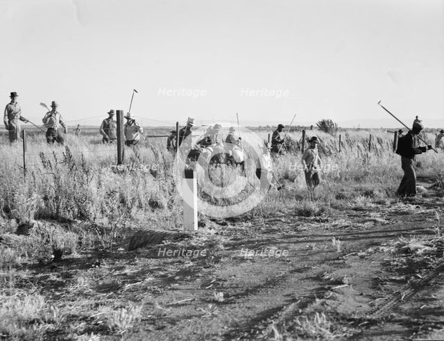 Migratory agricultural workers - cotton hoers, near Los Banos, California, 1939. Creator: Dorothea Lange.