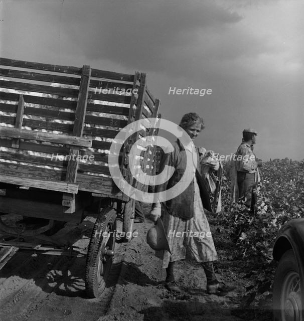 Migratory cotton pickers have stopped working because it started to rain, Kern County, CA, 1938. Creator: Dorothea Lange.