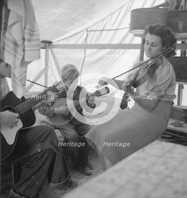 Migrant family from Arkansas playing hill-billy songs, FSA...migratory camp, Calipatria, CA, 1939. Creator: Dorothea Lange.