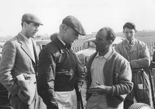 Mike Hawthorn and Stirling Moss chatting at Goodwood 1956. Creator: Unknown
